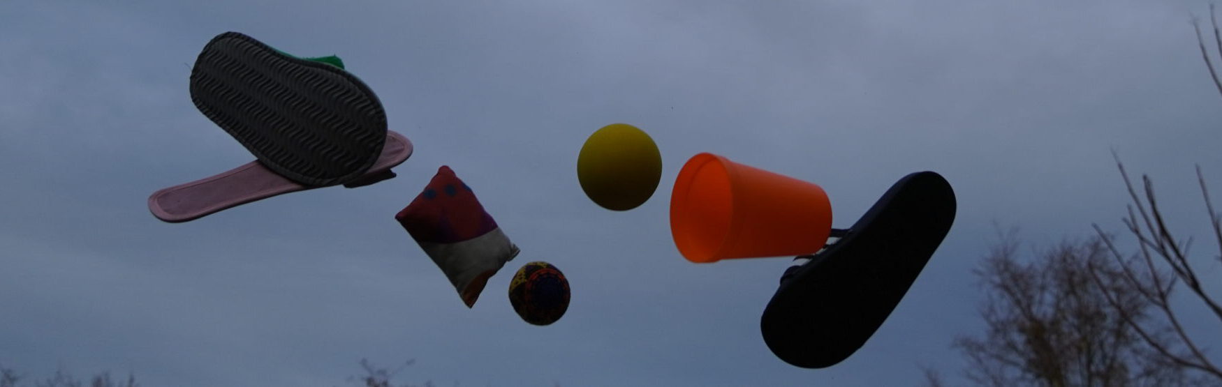 Bälle, Schlappen, ein Becher und ein Sandsäckchen fliegen durch die Luft